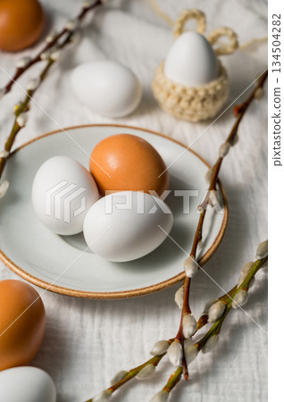 Easter background. Willow branches, white eggs in a plate. Spring time. Minimalistic top view 134504282