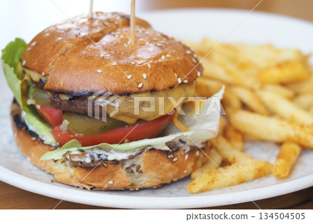Tasty burger with fries served on a plate at a restaurant Tasty burger with fries served on a plate at a restaurant 134504505