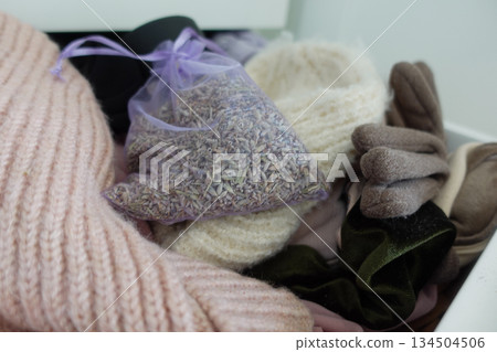 A bag of lavender sits with winter clothes in a drawer A bag of lavender sits with winter clothes in a drawer 134504506