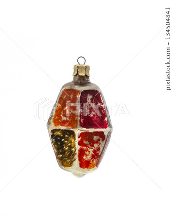 Vintage multicolored geometric glass Christmas ornament with worn paint, isolated on white background. 134504841