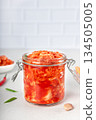 Glass jar with Korean kimchi on white kitchen. Spicy fermented cabbage with chili and garlic. Probiotic food. Copy space 134505005