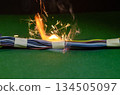 Bright electric sparks escape from a bundle of cables during a short circuit. 134505097