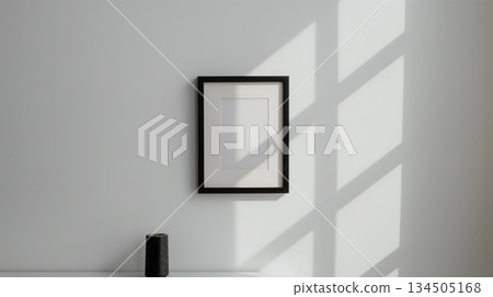 Minimal empty picture frame on wall with window shadow 134505168