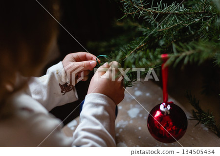 Children hands decorating Christmas tree at home 134505434