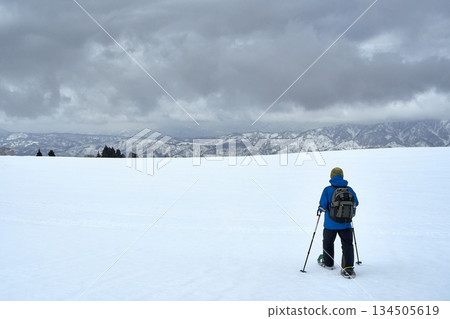 Snowshoe climbers walking through the snowy fields in winter 134505619