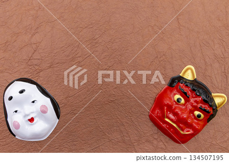 Red demon and okame masks arranged on a brown Japanese paper background Setsubun/good luck image 134507195