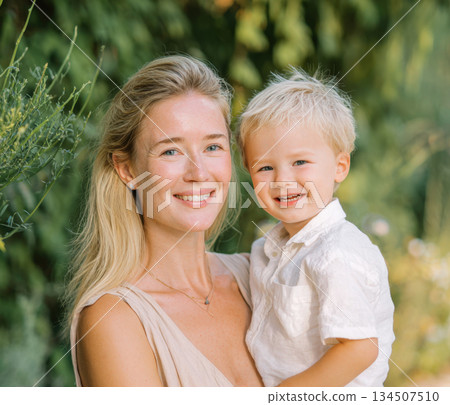 mother and son sharing a joyful moment in nature. The genuine laughter and affection are perfect for themes of motherhood, parenting, family love, childcare, summer lifestyle, and outdoor leisure. 134507510