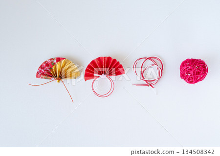 Red and gold fans and mizuhiki New Year's decorations lined up on a white background Red and gold fans and mizuhiki New Year's decorations lined up on a white background 134508342