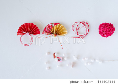 Red and gold fans and mizuhiki New Year's decorations lined up on a white background Red and gold fans and mizuhiki New Year's decorations lined up on a white background 134508344