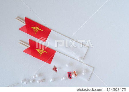 裝在紅白筷袋裡的慶祝筷子和新年裝飾品 裝在紅白筷袋裡的慶祝筷子和新年裝飾品 134508475