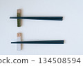 Ceramic chopstick rest and black chopsticks on a white background 134508594