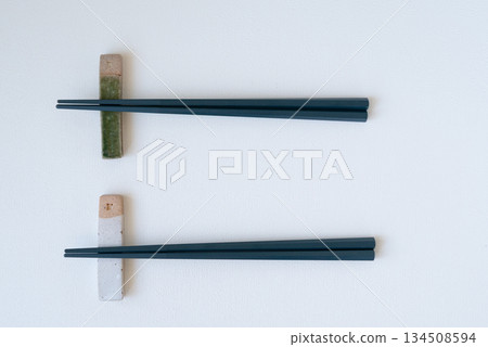 白色背景上的陶瓷筷架和黑色筷子 白色背景上的陶瓷筷架和黑色筷子 134508594