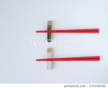Ceramic chopstick rest and red chopsticks on a white background Ceramic chopstick rest and red chopsticks on a white background 134508596