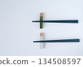 Ceramic chopstick rest and black chopsticks on a white background 134508597