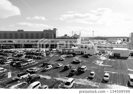"Black and white" cars lined up in Parking Lot B with the domestic terminal at "New Chitose Airport" in the background in winter 134509599