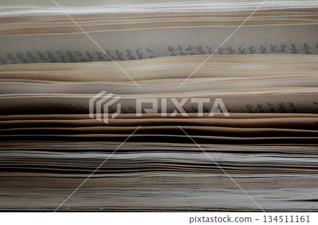 Books with worn pages are organized on a wooden shelf. 134511161