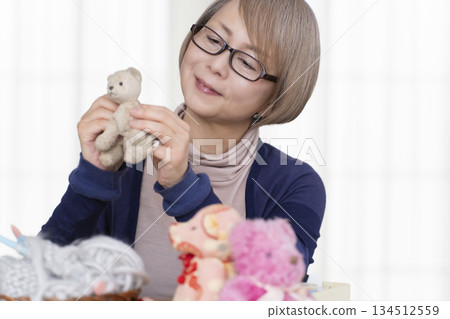 Senior woman making stuffing in the living room Senior woman making stuffing in the living room 134512559