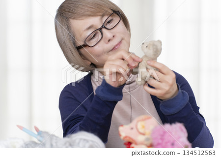 Senior woman making stuffing in the living room Senior woman making stuffing in the living room 134512563
