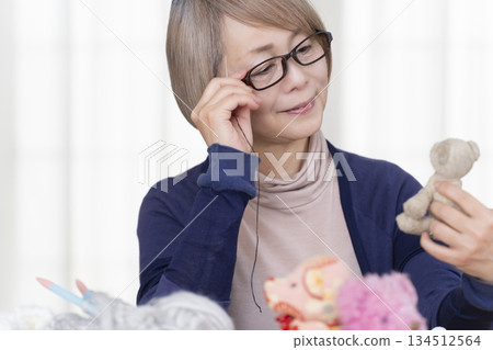 Senior woman making stuffing in the living room Senior woman making stuffing in the living room 134512564