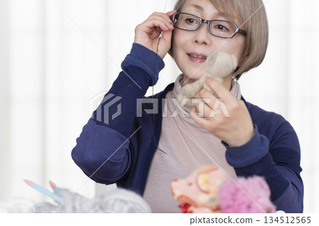 Senior woman making stuffing in the living room Senior woman making stuffing in the living room 134512565