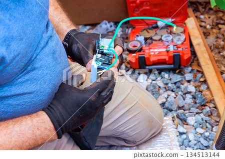 Man works with electrical tools at construction site near rocks toolbox Man works with electrical tools at construction site near rocks toolbox 134513144