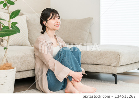 Smiling young Asian woman relaxing in the living room at home 134513262