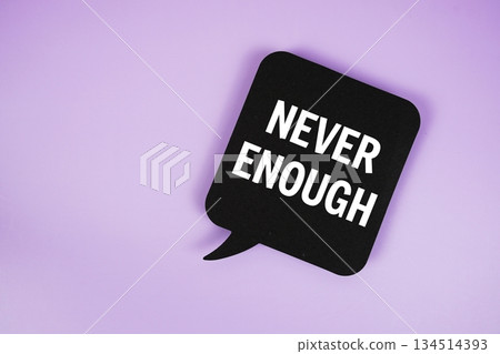 Never Enough text with speech bubble top view on purple background Never Enough text with speech bubble top view on purple background 134514393