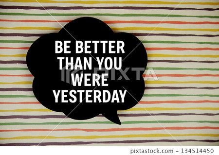 Be Better Than You Were Yesterday text with speech bubble top view on colorful stripes background Be Better Than You Were Yesterday text with speech bubble top view on colorful stripes background 134514450