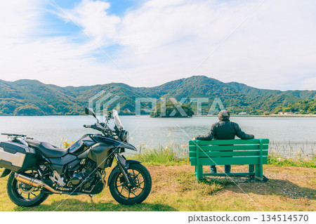A rider resting on a bench while touring Ise-Shima by motorcycle 134514570