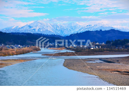 Early winter snow-capped scenery of the Echigo Sanzan mountains and Shinano River 134515469