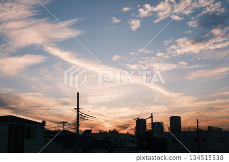 Streaky clouds and the silhouette of a cityscape at dusk Streaky clouds and the silhouette of a cityscape at dusk 134515538