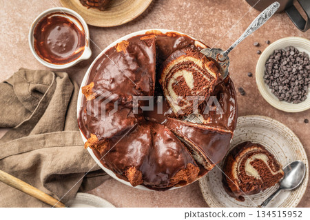 Chocolate marble bundt cake or zebra cake with chocolate glaze sliced on brown table background top view Chocolate marble bundt cake or zebra cake with chocolate glaze sliced on brown table background top view 134515952
