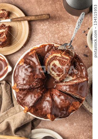 Chocolate marble bundt cake or zebra cake with chocolate glaze sliced on brown table background top view, close up Chocolate marble bundt cake or zebra cake with chocolate glaze sliced on brown table background top view, close up 134515953