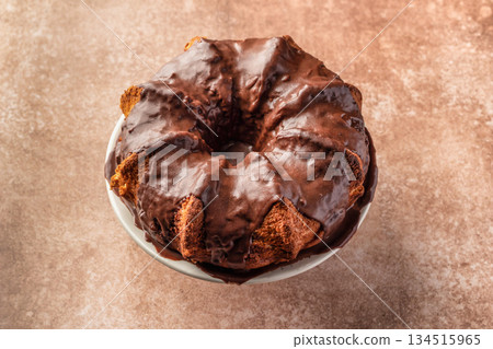 Chocolate marble bundt cake or zebra cake with chocolate glaze on brown table background isolated 134515965