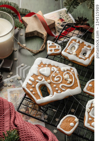 Homemade gingerbread house. Pieces for building a gingerbread house decorated with sugar icing on festive wooden table. Christmas Holiday tradition Homemade gingerbread house. Pieces for building a gingerbread house decorated with sugar icing on festive wooden table. Christmas Holiday tradition 134515989