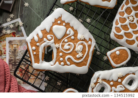 Homemade gingerbread house. Pieces for building a gingerbread house decorated with sugar icing on festive wooden table. Christmas Holiday tradition, top view 134515992