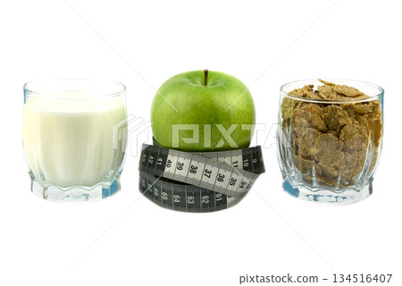 Green apple and black and white measuring tape, oatmeal, kefir, cereal flakes. 134516407