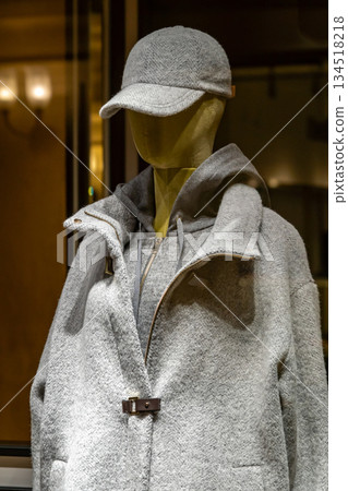 Grey Wool Coat and Cap On Mannequin Display In Store Window For Winter Fashion Grey Wool Coat and Cap On Mannequin Display In Store Window For Winter Fashion 134518218
