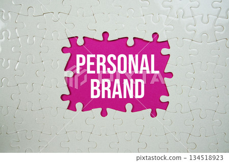 Jigsaw puzzle with a missing piece with "Personal Brand" on pink background 134518923