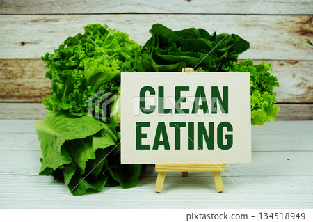 "Clean Eating" message on a small easel next to a basket of fresh green leafy vegetables 134518949
