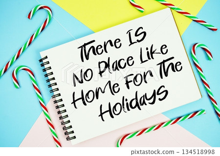 There Is No Place Like Home For The Holidays message of season holidays written on notepad with candy cane decoration on pastel background There Is No Place Like Home For The Holidays message of season holidays written on notepad with candy cane decoration on pastel background 134518998