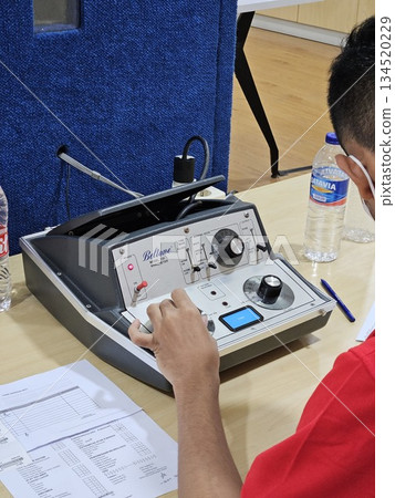 This is a man with digital equipment for ear test This is a man with digital equipment for ear test 134520229