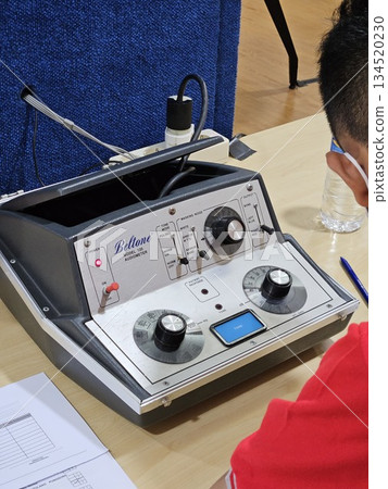 This is a man with digital equipment for ear test  134520230