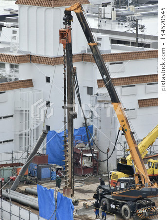 A large crane driving piles at a construction site 134520545