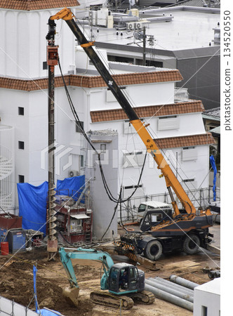 A large crane driving piles at a construction site A large crane driving piles at a construction site 134520550