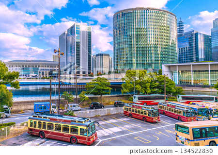 這是日本橫濱的城市景觀，包括K Arena體育館、橫濱希爾頓酒店以及新高島車站前的建築。前景中可以看到一雙紅色的鞋子。 134522830