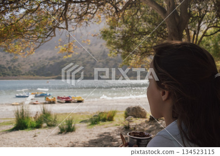 Child having ice cream outdoors with a scenic lake backdrop Child having ice cream outdoors with a scenic lake backdrop 134523115