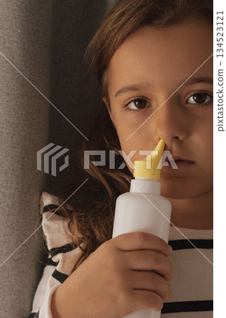 Applying unbranded saline nasal spray for respiratory hygiene and allergy relief Applying unbranded saline nasal spray for respiratory hygiene and allergy relief 134523121