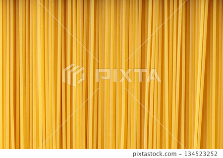 Uncooked Spaghetti Creating Yellow Food Background Close-Up 134523252