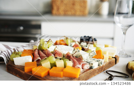 Cheese Board With Fruits And Ham On A Table Cheese Board With Fruits And Ham On A Table 134523486